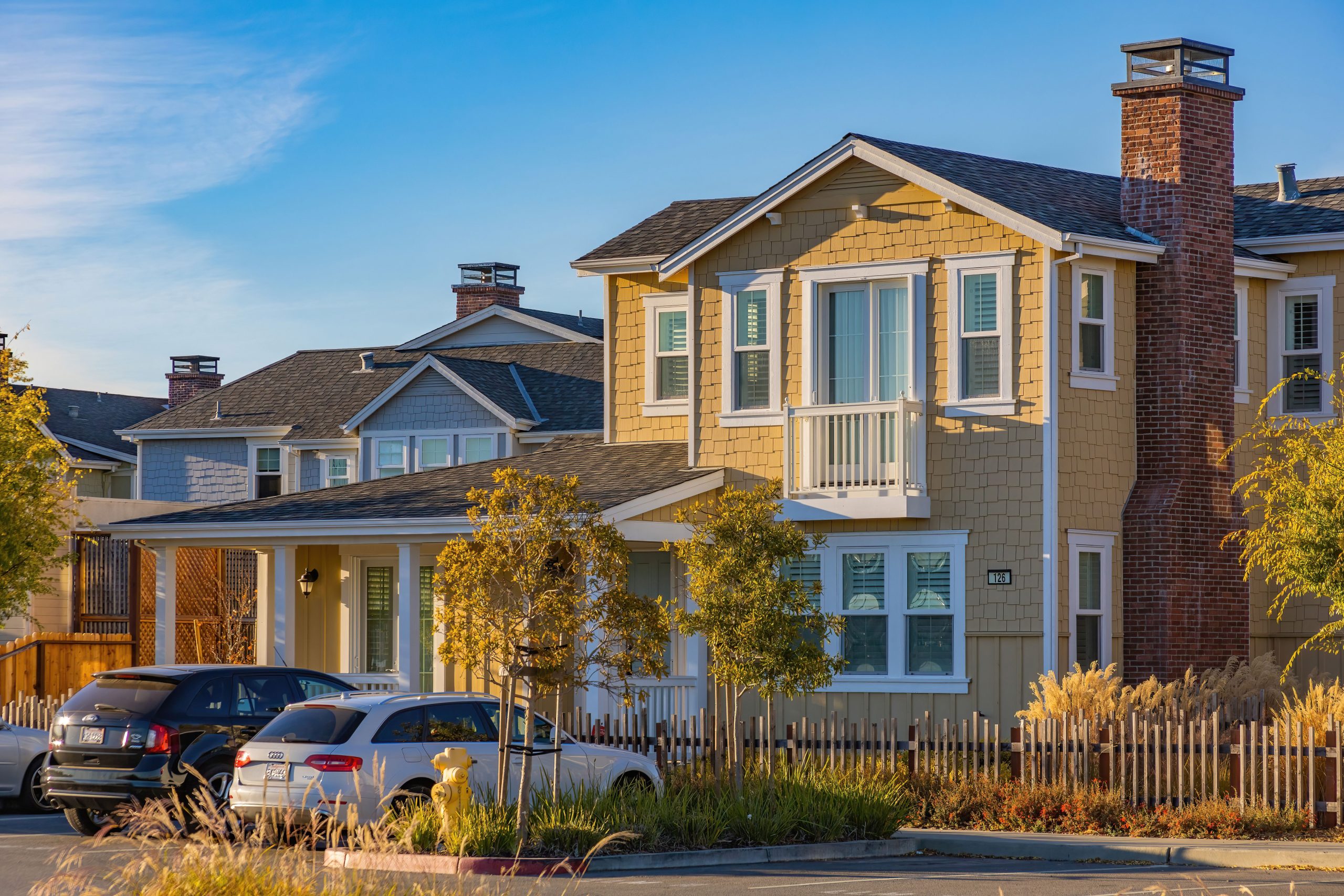 Suburban homes with front lawns and parked cars, Downriver housing market